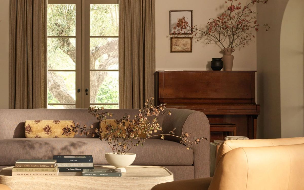 A serene living room styled in warm neutral tones with layered textures and natural materials